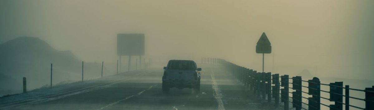 A Pickup Truck on a Hazy Road During a Storm